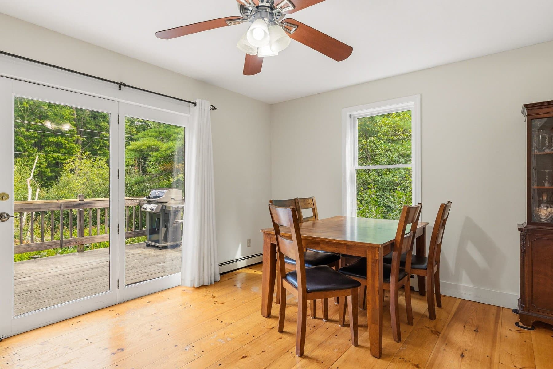 The dining area with a ceiling fan and the slider out to the deck