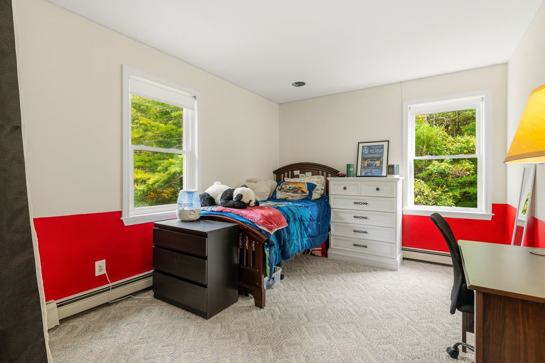 A bedroom with 2 windows, a desk, and red two-tone walls