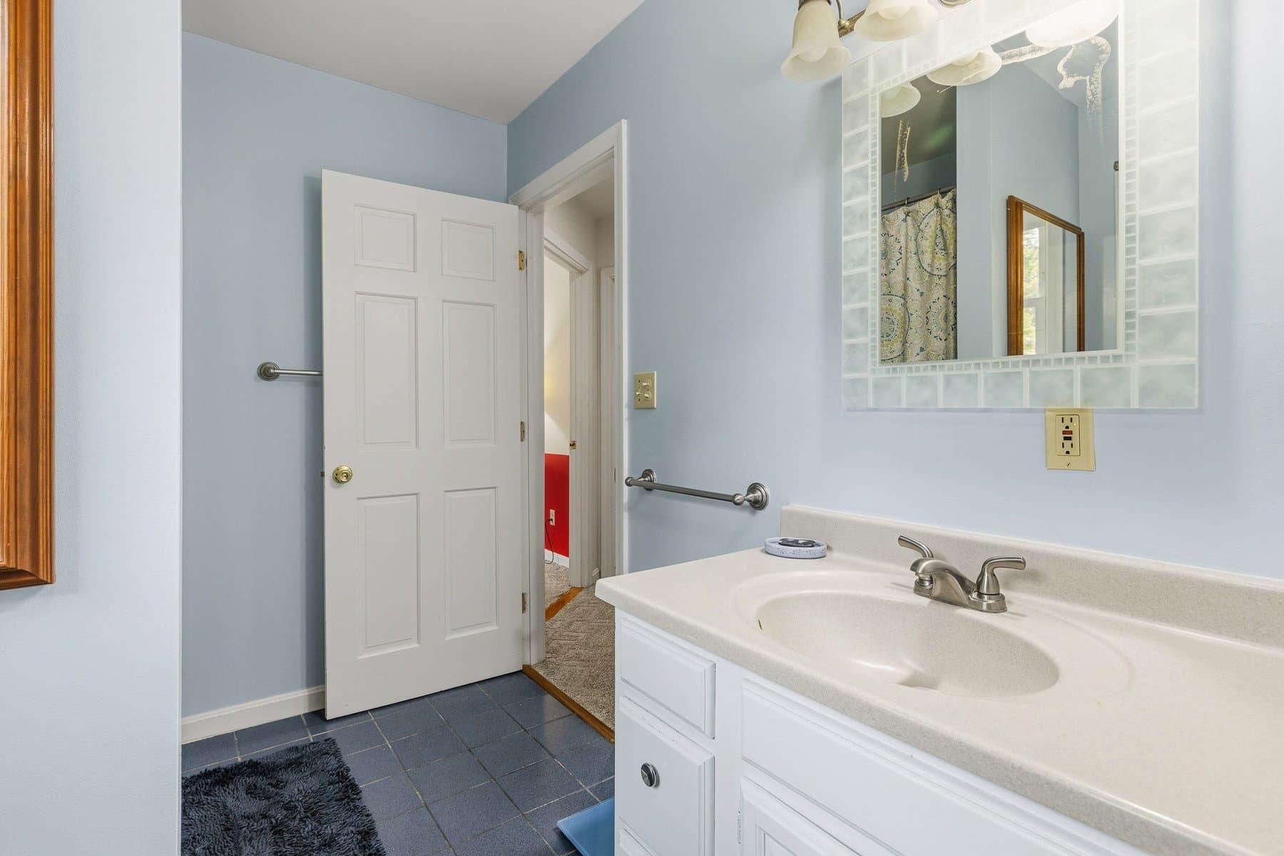 The full bath with a vanity, a slate tile floor, and the tub and shower in the mirror
