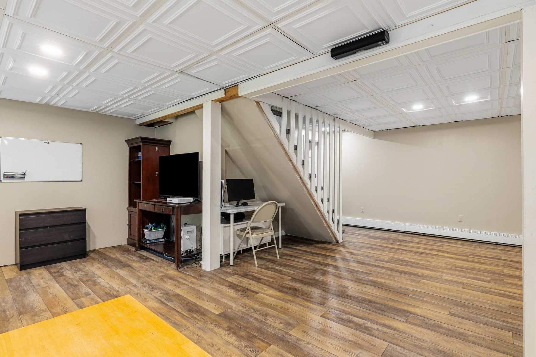 The office nook under the lower level stairs, with the wood-look floor